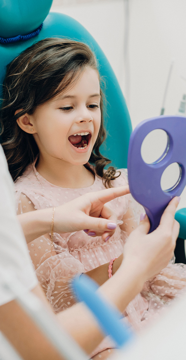 pediatric dentist showing to her patient the teeth